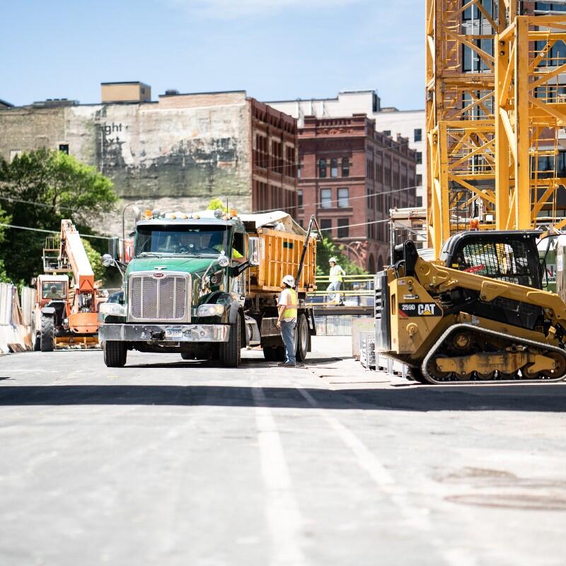 Construction workers collaborating on-site, focusing on effective waste disposal services for contractors and job sites.