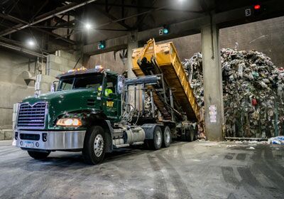 Veit Disposal truck disposing industrial waste in licensed recycling facility.